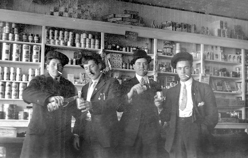 Young men drinking and smoking in a general store in Plamondon, Alberta in 1920 during prohibition